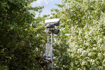CCTV camera hidden behind trees recording video