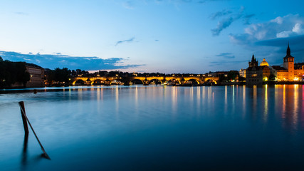 Illuminated Charles Bridge reflected in Vltava River by night. Prague, Czech Republic.