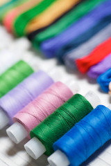 Close - up of coils of threads of different colors and shades for sewing, embroidery and creativity.