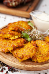 The concept of Ukrainian cuisine. Draniki from potatoes and pumpkins, with edible flowers. Copy space, selective focus