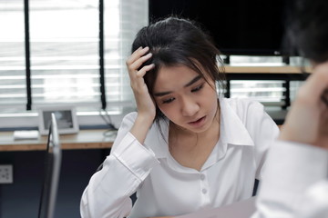 Upset young Asian business woman suffering from severe problem between meeting in office