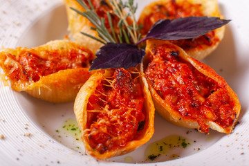 Italian pasta Conchiglioni Rigati. Delicious dish stuffed with ground meat with dry tomatoes in...