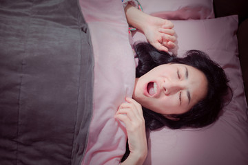 Snore problem concept. Asian women sleeping with her mouth open and snoring loudly .