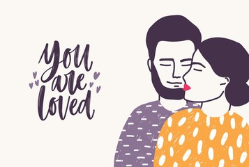 Bearded man embracing woman and You are loved romantic slogan written with cursive font
