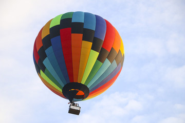 Obraz premium colorful hot air balloon against blue sky. hot air balloon is flying in white clouds. beautiful flying on hot air balloon