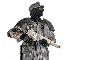 Nuclear post-apocalypse survivor, alternative history nazi soldier or partisan in wool field cap, face mask, glasses and handmade armor, aiming submachine gun in camera studio shoot isolated on white