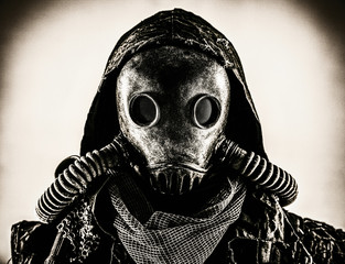 Close up portrait of nuclear post-apocalypse survivor, living underground mutant or creature, skilled stalker wearing rags and armored full-face gas mask or air breathing apparatus, toned shoot - obrazy, fototapety, plakaty