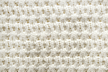 Cropped close up shot of seamless woolen knitting pattern of fall / winter season warm sweater, clearly visible fiber texture of stylish hipster knitwear clothing. Background, copy space, top view.