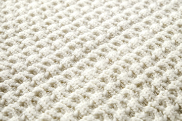 Cropped close up shot of seamless woolen knitting pattern of fall / winter season warm sweater, clearly visible fiber texture of stylish hipster knitwear clothing. Background, copy space, top view.