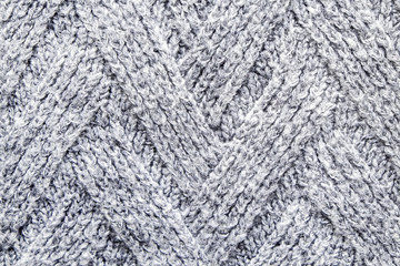 Cropped close up shot of seamless woolen knitting pattern of fall / winter season warm sweater, clearly visible fiber texture of stylish hipster knitwear clothing. Background, copy space, top view.