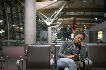 Woman using mobile phone in waiting area