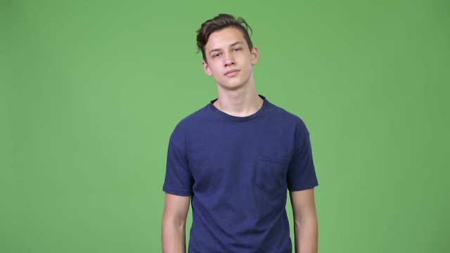 Young handsome teenage boy looking bored