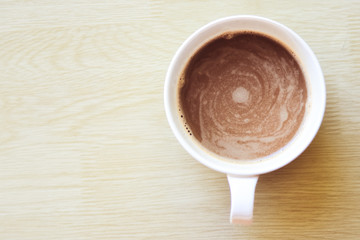 Coffee cup top view on wooden table background.