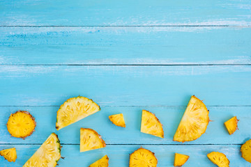 Tropical pineapple slices on wood plank blue color. frame layout summer vacation background concept. top view, pattern