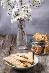 Homemade oatmeal cookies in a bowl and glass jar on grey vintage wooden table.  Traditional Swedish cookies Havrekakor