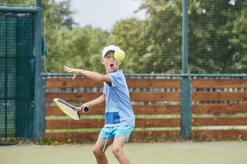 Little boy playing tennis