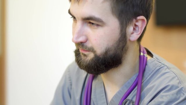 Young bearded doctor in hospital room