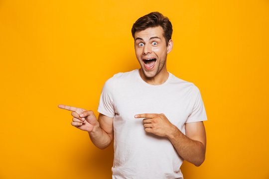 Portrait of a cheerful young man pointing fingers