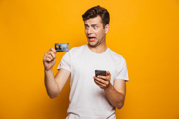 Portrait of a frustrated young man holding mobile phone