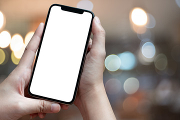 Mockup image of hand holding mobile phone with blank white Full screen in cafe