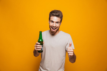 Portrait of a cheerful young man holding beer bottle