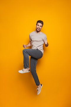 Full length portrait of a cheerful young man jumping