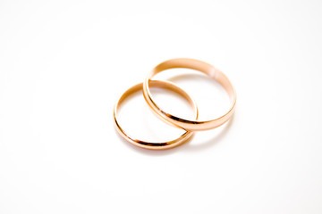 love, family, celebration, ceremony concept -wedding symbols two golden rings on white background