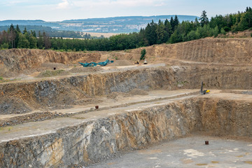 Opencast mining quarry with lots of machinery. Mining in the granite quarry. Working mining machine...