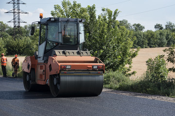 Road roller on asphalt. Summer sunny day