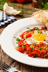 Shakshouka, dish of eggs poached in a sauce of tomatoes, chili peppers, onions