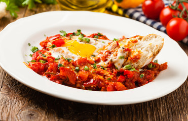Shakshouka, dish of eggs poached in a sauce of tomatoes, chili peppers, onions