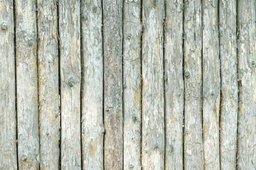 Fence from gray old unprocessed logs