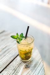 Mojito cocktail on the wooden table at a sunny day
