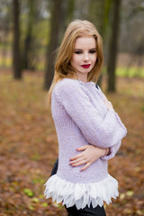 Obraz premium Autumn portrait of the woman in a sweater from woolen strings of handwork