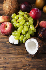 Concept of vegan food with coconut, grape, peache and plums