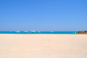 Fototapeta na wymiar Mahmya island at Red Sea in Egypt, idyllic beach of Mahmya island with some boats in turquoise water, Egypt
