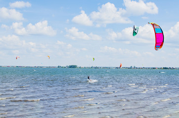 Sky surfers ride around the lake on a summer sunny day on the waves