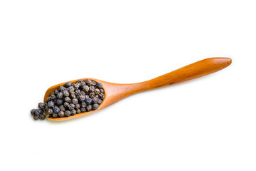 Black pepper on wooden spoon isolated on white background