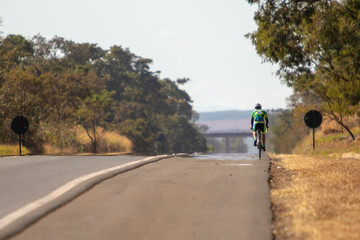 Obraz premium Ciclista pedalando em uma estrada