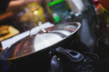 Cook closes the pan with a lid during cooking.