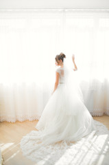 Fototapeta premium Luxury bride in white dress posing while preparing for the wedding ceremony