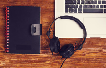 top view laptop headphones diary book on wooded table, vintage look