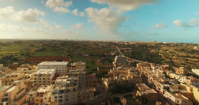 A long Aerial Shot from a small city to fields