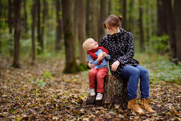 Little boy with his young mother enjoy stroll in the forest