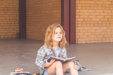 at recess at school girl, child out, at lunch with a book