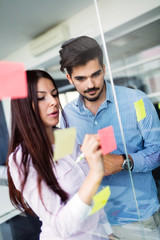 Businesswoman using sticky notes at office to plan project