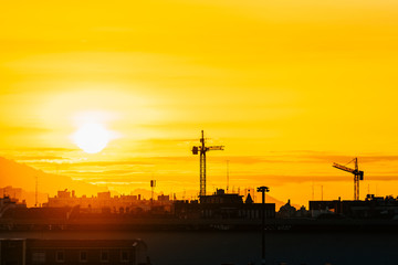 Fototapeta na wymiar silhouette of construction cranes at sundown