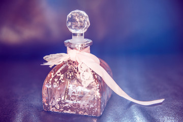 Pink Shabby Chic Glass Bottle with Lace and Key on Dark Leather Sofa.