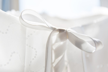 Fototapeta na wymiar White Bridal Dress Back Knot and Lace Details Backlit
