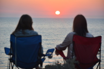 Two girls watching sunset in Bozcaada, Canakkale, Turkey